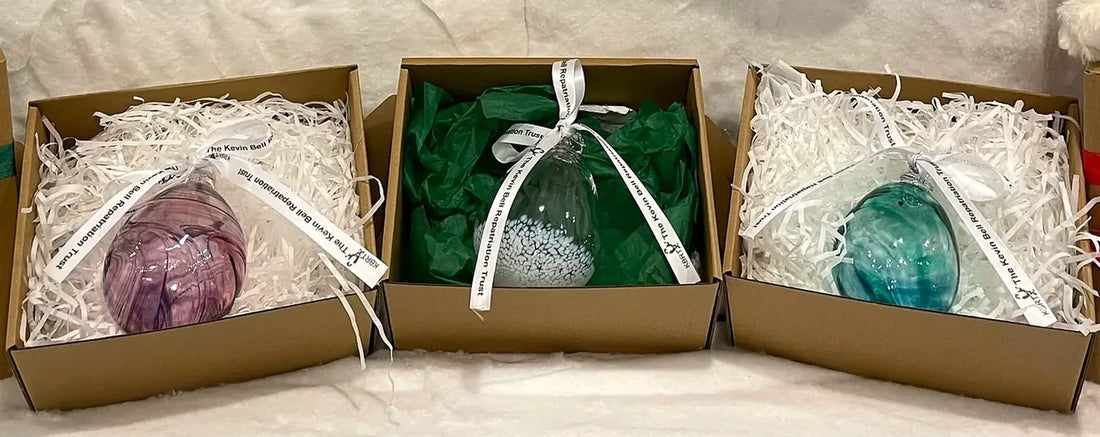 Berry, Clear and Green hand-blown baubles, each in its gift box with the Kevin Bell Repatriation Trust ribbon