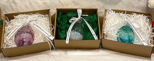 Berry, Clear and Green hand-blown baubles, each in its gift box with the Kevin Bell Repatriation Trust ribbon
