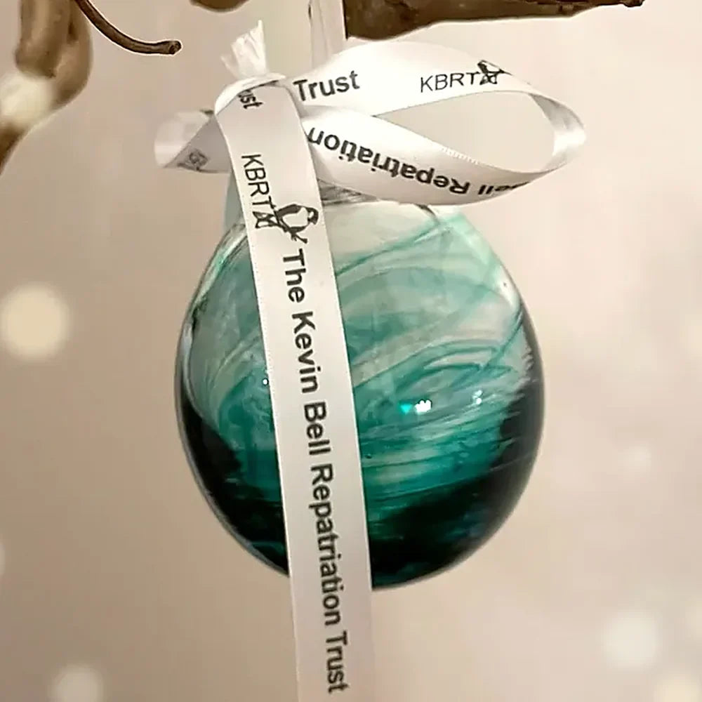 Green hand-blown glass bauble with the Kevin Bell Repatriation Trust ribbon